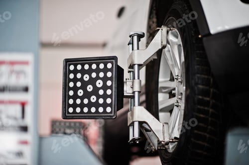 Preview: American SUV car on stand for wheels alignment camber check in workshop of service station.