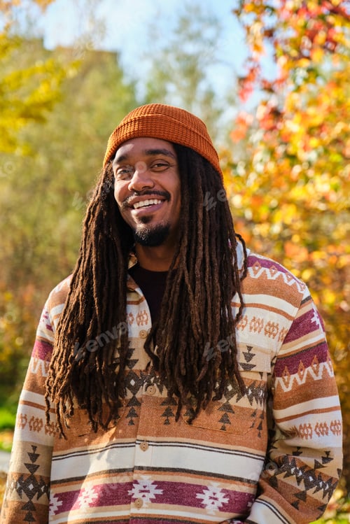Preview: African young man with dreadlocks smiling and looking at camera in fall.