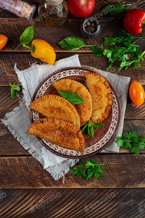Preview: Traditional Crimean Tatar cuisine, chebureki with chicken meat. Fried empanadas on wooden background
