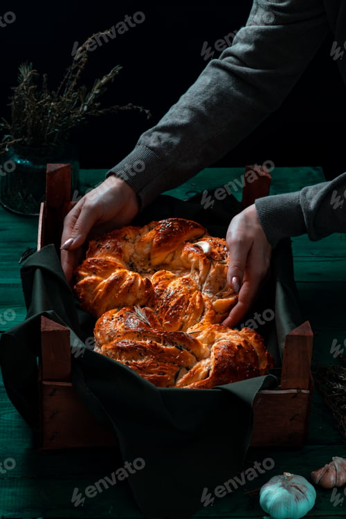 Preview: Freshly made Italian bread on greenwooden board with herbs and garlic, Mediterranean Food background