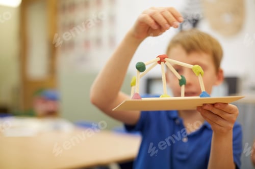 Preview: Child showcasing a creative project in a classroom setting