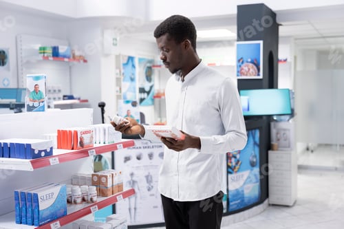 Preview: Black male client examining cardiology pills and vitamins for prevention