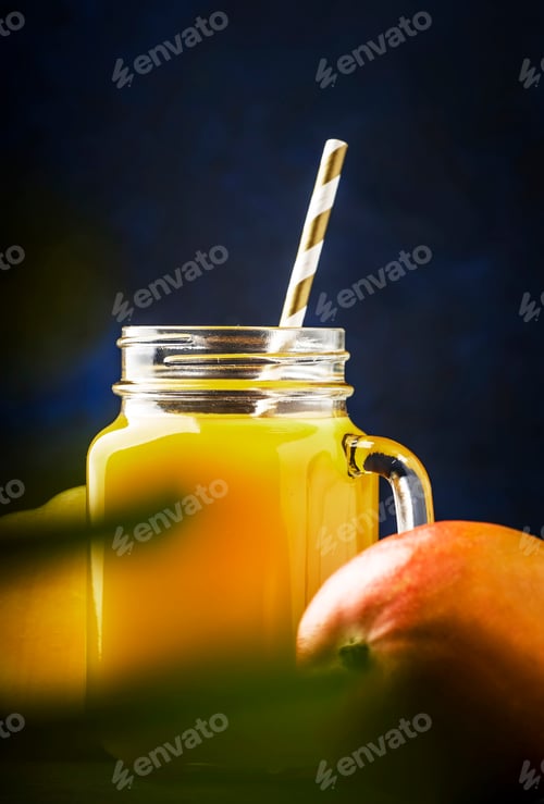 Preview: Mango smoothie or cocktail in glass jar with fresh fruit