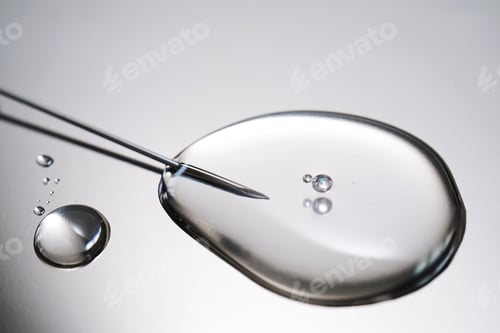 Preview: A drop of medicine flowing from a syringe with a needle.