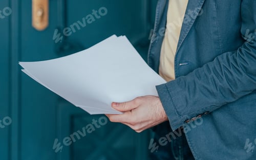Preview: The man in blue jacket suit holding sheets of paper in his hands, close up