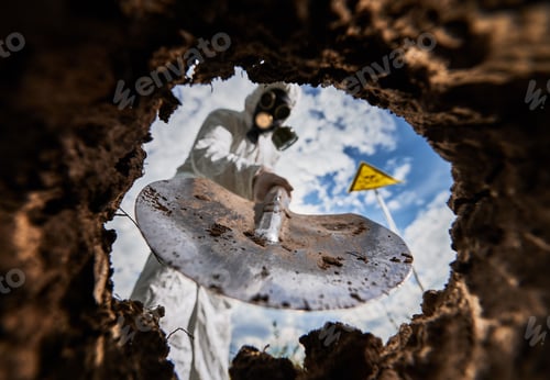 Preview: Ecologist digging pit by shovel and planting tree in polluted area.