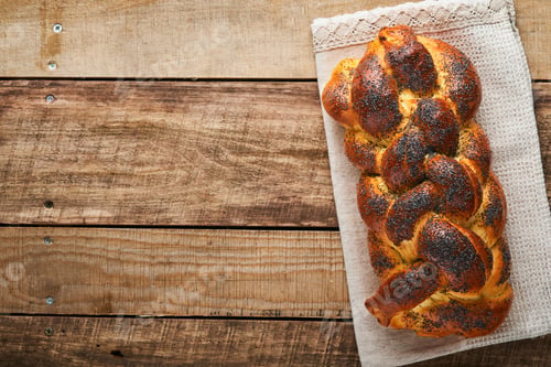 Preview: Shabbat Shalom. Bread challah with sesame seeds and poppy seeds on wooden background. Traditional je