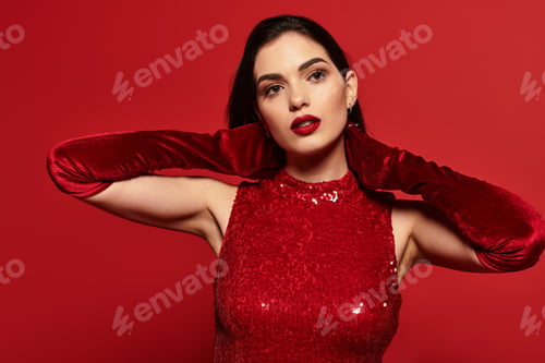 Preview: Captivating beauty in a vibrant red attire against a bold backdrop