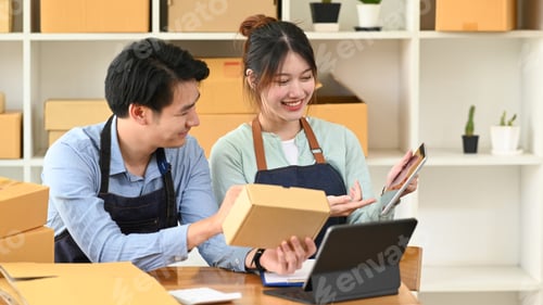 Preview: Two business partner preparing parcel boxes of product for delivery to customers.