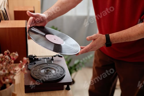 Preview: Senior Man Setting Vinyl Record on Retro Record Player at Home