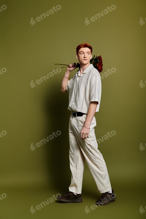 Preview: Young man expressing emotions while holding flowers against a green backdrop