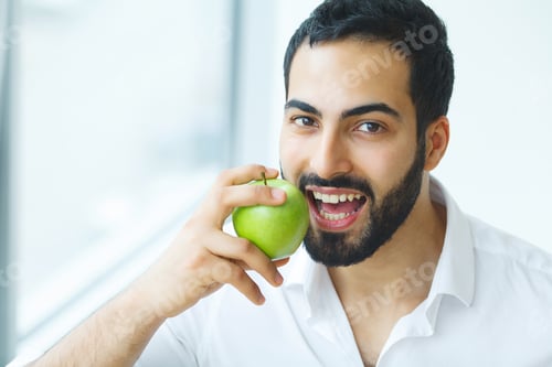 Preview: Man With Apple. Beautiful male With White Smile, Healthy Teeth. High Resolution Image