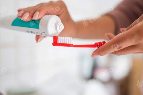 Preview: a girl in the bathroom with toothpaste and a brush in her hands for clean teeth