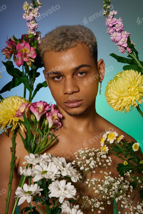 Preview: Young man with dyed hair embraces nature in artistic studio setting with flowers