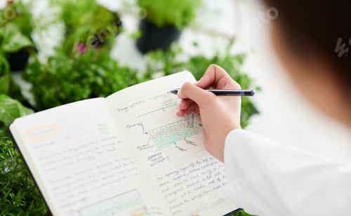 Preview: Closeup shot of an unrecognisable scientist writing notes about plants in a lab