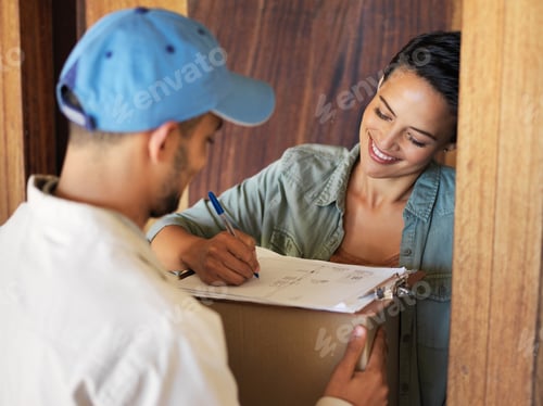 Preview: Shot of a young woman standing at her front door signing for a package from a courier