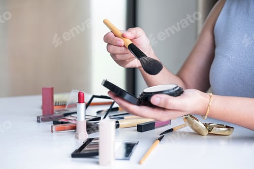 Preview: Woman Applying Makeup with Brush in Indoor Setting