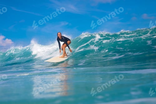 Preview: Female surfer on a blue wave