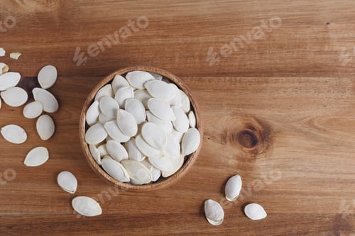 Preview: Bowl with a pumpkin seeds on a wooden table