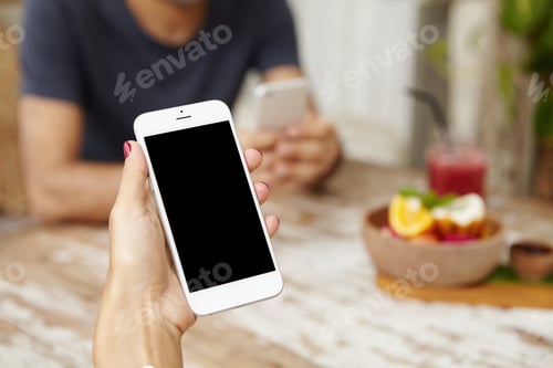 Preview: Close up shot of woman's hand holding generic mobile phone with blank copy space screen for your tex