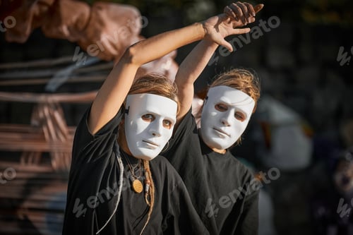 Preview: Two girls in white theatre mask dancing on art festival, outdoor art theatrical performance festival