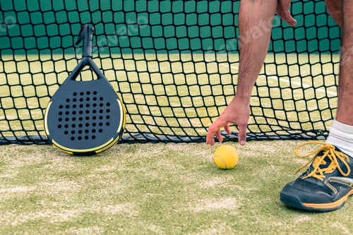 Preview: Monitor of padel holding yellow ball near racket with copy space. Racquet sport