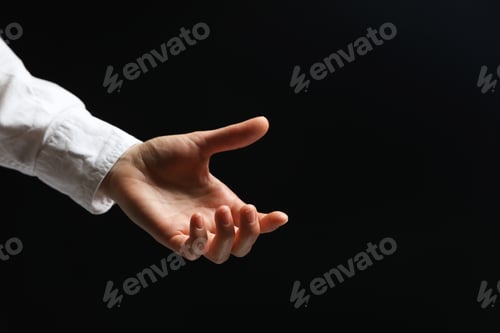 Preview: Woman holding something in hand on black background, closeup. Space for text