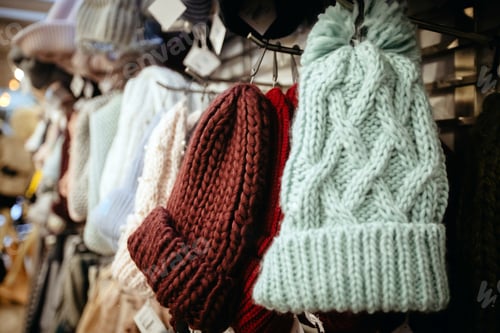 Preview: Knitted warm hats hanging on hanger in store