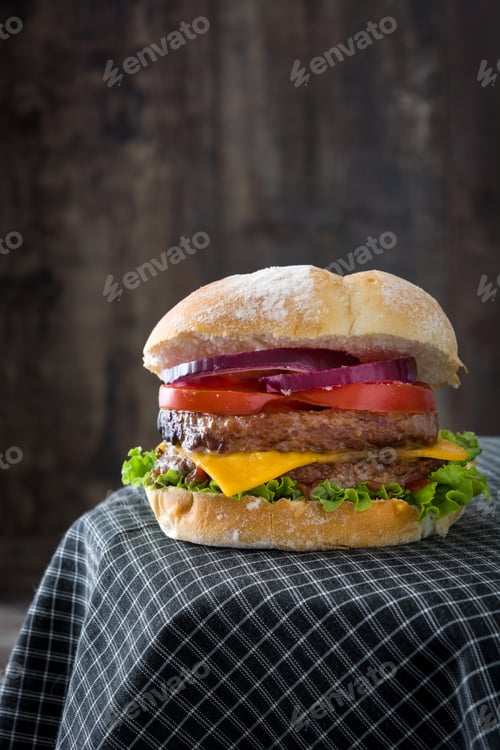 Preview: Delicious double burger resting on checkered tablecloth with rustic background