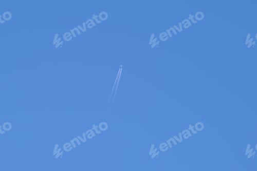 Preview: Distant passenger jet plane flying on high altitude on clear blue sky leaving white smoke