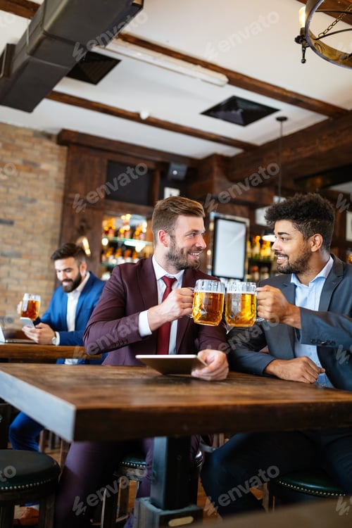 Preview: People, friendship and celebration concept. Happy business male friends drinking beer at pub