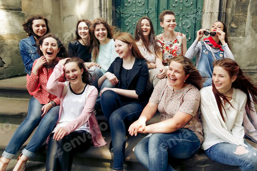 Preview: young happy women sitting on stairs posing