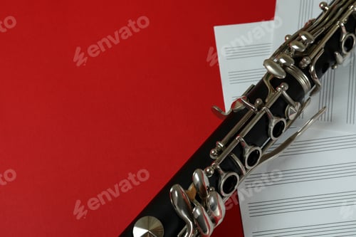 Preview: Clarinet and music sheets on red background