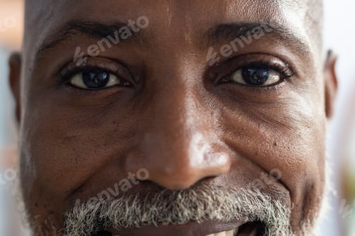 Preview: Portrait of happy african american male doctor looking at camera and smiling at doctor's office
