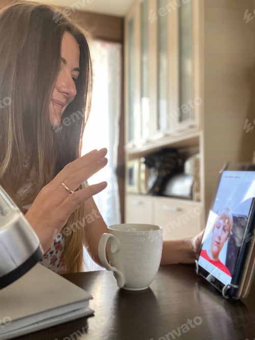 Preview: Middle aged Caucasian woman with long blond hair has video chat sitting in the kitchen