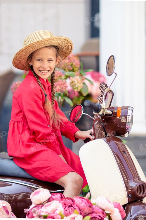 Preview: Adorable little girl in hat on the moped outdoors
