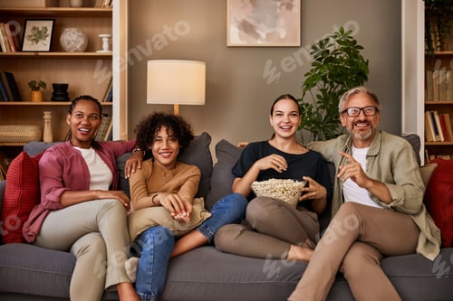 Visualização: Retrato de uma família alegre assistindo a um filme em casa.
