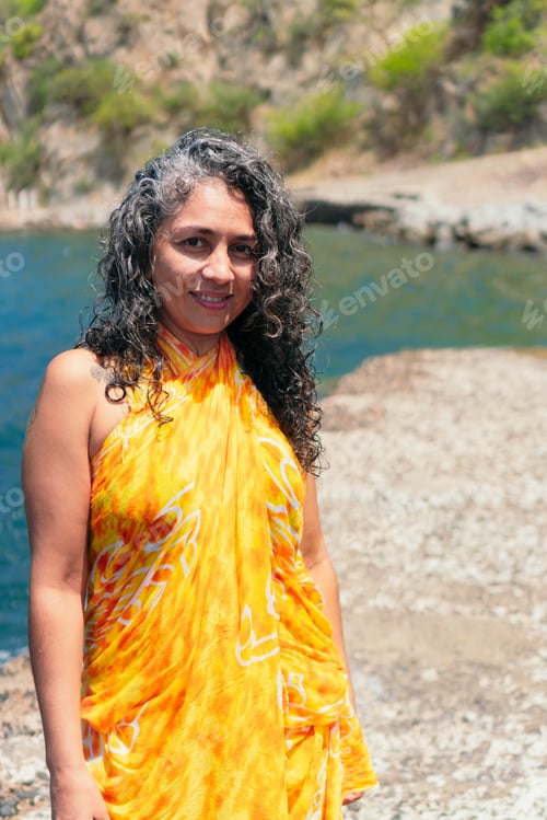 Preview: Contemplative ethnic traveler in pareo on pier against sea