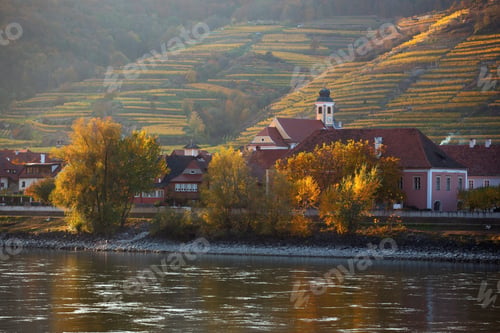 Preview: autumn view of small austrian village on a river bank