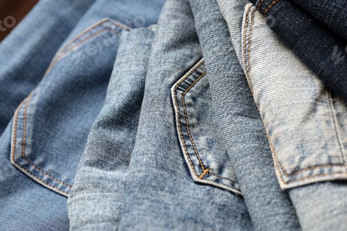 Preview: Many jeans in stack in wardrobe room. Row of pants denim jeans in closet. Concept of buy,
