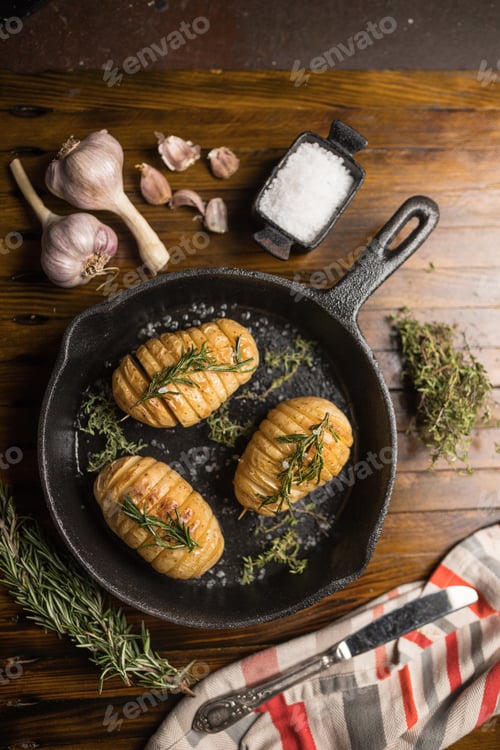 Preview: Overhead shot of potatoes in a frying pan with ingredients on a wooden table