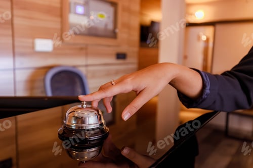 Preview: Hotel receptionist rings bell to signal guest check-in at modern lobby during daytime