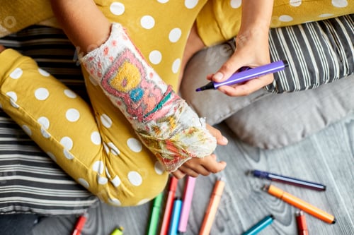 Preview: Teen girl with a broken arm at home draws an orthopedic cast