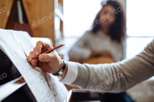 Preview: Man playing piano near woman playing guitar in studio
