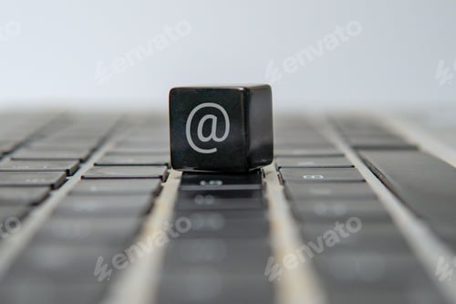 Preview: A cube with an at sign or at symbol on a laptop keyboard.