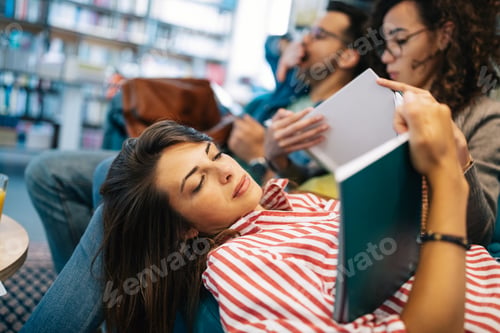 Preview: College, study, university and education concept. Group of tired students learning in library