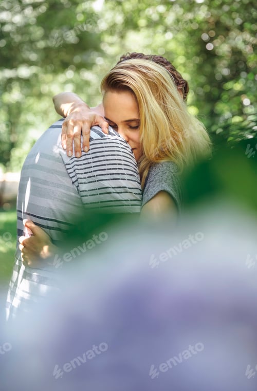 Preview: Romantic couple hugging behind an unfocused bouquet of flowers