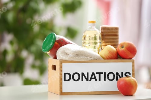 Preview: Donation box with food products on table indoors