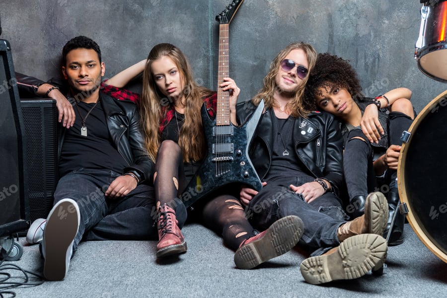 Cover for rock band sitting on floor while resting after rehearse in studio