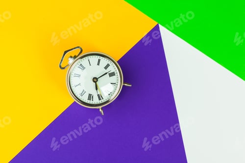 Preview: Black alarm clock on color block background, office interior